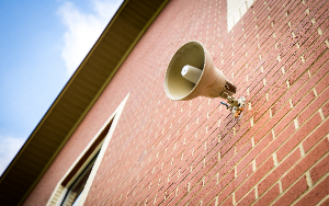  Intercom speaker mounted on a brick wall.